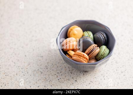 Süßes Makronen-Dessert. Bunte Makronen in Schale auf dem Küchentisch. Stockfoto