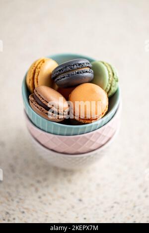 Süßes Makronen-Dessert. Bunte Makronen in Schale auf dem Küchentisch. Stockfoto