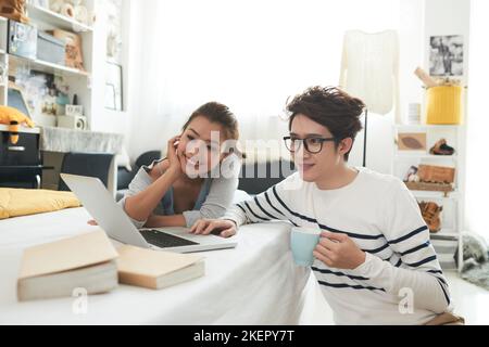 Junges vietnamesisches Paar, das zu Hause einen Film auf dem Laptop ansieht Stockfoto