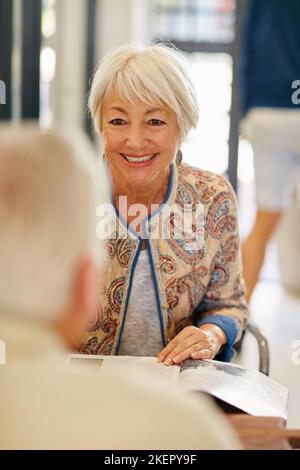Sie finden sich immer noch so interessant. Ein lächelndes Seniorenpaar, das sich in einem Café zusammenfindet. Stockfoto