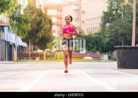 lateinische Sportlerin, die auf der Stadt läuft Stockfoto