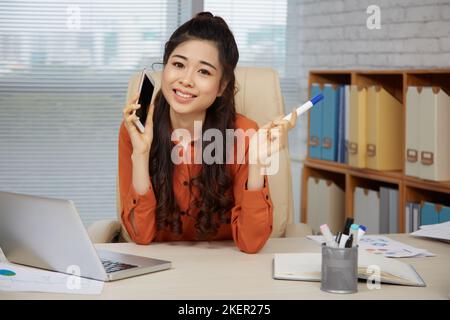 Porträt einer schönen jungen Unternehmerin an ihrem Arbeitsplatz im Büro Stockfoto