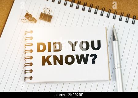 Wirtschafts- und Geschäftskonzept. Auf dem Tisch befinden sich ein Stift, Klemmen und ein Notizbuch mit der Aufschrift - WUSSTEN SIE SCHON Stockfoto