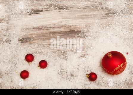 Rot-weiße Weihnachtsdekorationen auf grauem Hintergrund mit künstlichem Schnee Stockfoto