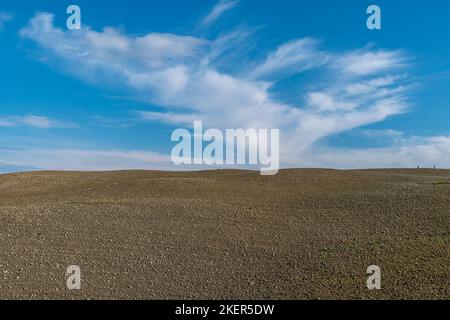 Ein gepflügtes Feld vor einem schönen Himmel in der toskanischen Landschaft während der Wintersaison, Casciana Terme, Pisa, Italien Stockfoto
