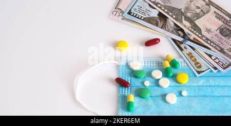 Dollar in einer medizinischen Maske, umgeben von Drogen und Pillen. Das Konzept von Medecine. Aufgenommen von oben auf weißem Hintergrund. Stockfoto