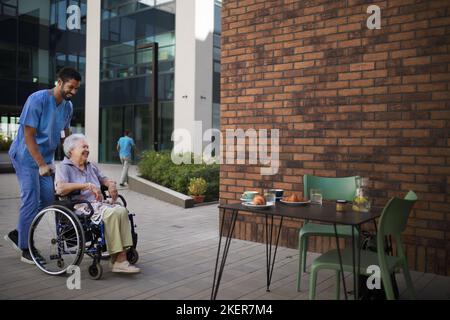 Pfleger beim Frühstück mit seinem Kunden im Café. Stockfoto