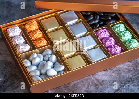 Verpackte Schokolade auf dunklem Hintergrund. Schokolade in Geschenkverpackung Stockfoto