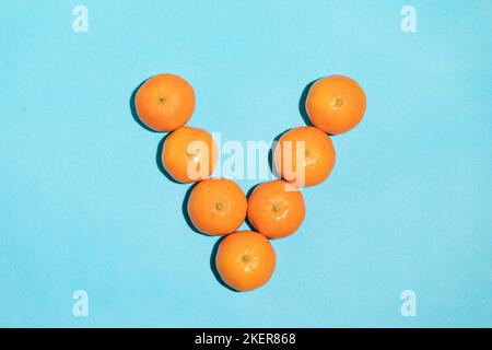 Saftige natürliche Mandarinen bilden den Buchstaben V Stockfoto