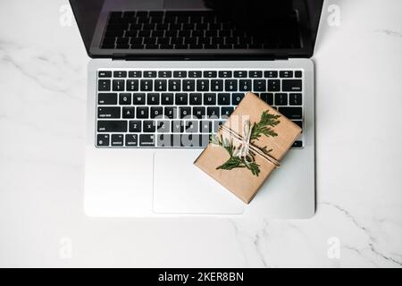 Tech-Geschenke für Weihnachten für den technisch versessenen Menschen. Gadgets und Geräte Weihnachten Geschenkideen. Laptop mit Weihnachts-Geschenkschachteln auf dem Tisch Stockfoto