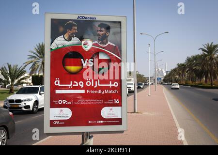 14. November 2022, Oman, Maskat: Auf einer Straße neben dem Stadion ist ein Werbedisplay zu sehen, das das Freundschaftsspiel zwischen der deutschen Fußballnationalmannschaft und der Nationalmannschaft von Oman anzeigt. Mit dem Freundschaftsspiel am 16. November 2022 will sich die Nationalmannschaft des Oman auf den Start der WM im Sultan Qabus Sports Center in Muscat vorbereiten. Im Hintergrund ist die Mohammed Al Ameen Moschee zu sehen. Foto: Christian Charisius/dpa - WICHTIGER HINWEIS: Gemäß den Anforderungen der DFL Deutsche Fußball Liga und des DFB Deutscher Fußball-Bund ist es verboten, o zu verwenden Stockfoto