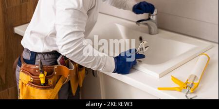 Männer, die im Badezimmer ein Waschbecken befestigten Stockfoto