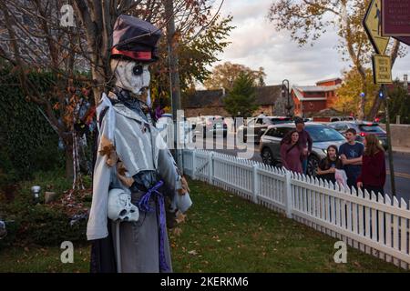 New Hope, PA, USA - 5. Nov 2022: Fußgänger beobachten an einem warmen Herbsttag Halloween-Dekorationen in einem Haus entlang der Main Street. Stockfoto