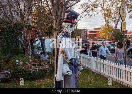 New Hope, PA, USA - 5. Nov 2022: Fußgänger beobachten an einem warmen Herbsttag Halloween-Dekorationen in einem Haus entlang der Main Street. Stockfoto