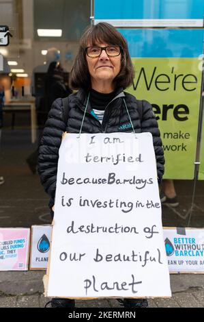 London, Großbritannien. 14. November 2022. Klimaaktivisten vom Aussterben Rebellion und Geldaufstand protestieren vor der Barclays-Niederlassung in Tooting, Süd-London, in einer britischen Kampagne mit dem Titel „besser ohne Barclays“. Die Demonstranten halten ein Plakat, das Barclays anprangert, in fossile Brennstoffe zu investieren. Quelle: Andrea Domeniconi/Alamy Live News Stockfoto