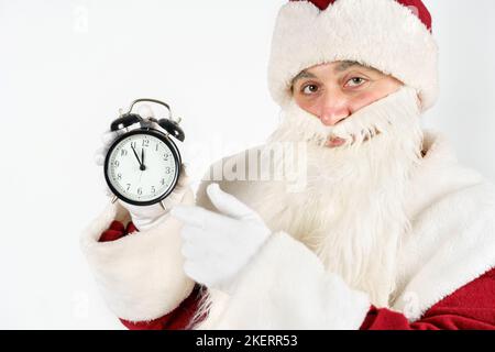 Weihnachten und Weihnachtskonzepte. Der Weihnachtsmann zeigt die verbleibende Zeit vor Weihnachten auf der Uhr an. Isoliert auf Weiß Stockfoto