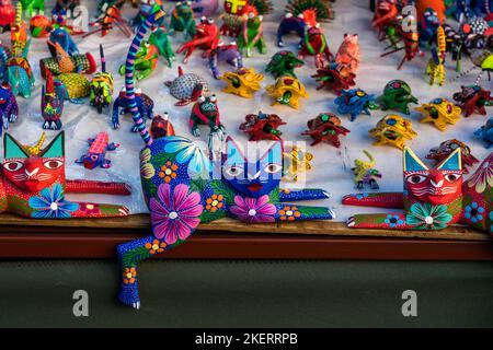 Bunt bemalte alebrijes aus kopalem Holz geschnitzt, die echte und mythische Kreaturen zum Verkauf in Oaxaca, Mexiko darstellen. Stockfoto