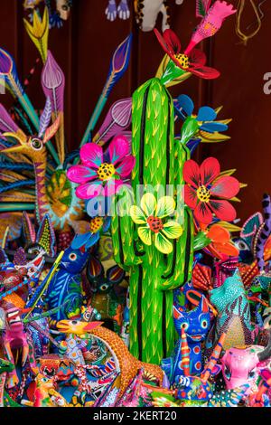 Bunt bemalte alebrijes aus kopalem Holz geschnitzt, die echte und mythische Kreaturen zum Verkauf in Oaxaca, Mexiko darstellen. Stockfoto