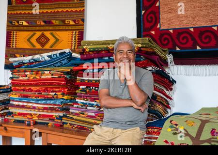 Weber Jeronimo Vasquez G. mit Wollteppichen im Familienwebgeschäft in Teotitlan, Oaxaca, Mexiko. Das Garn wird mit allen natürlichen Farbstoffen gefärbt Stockfoto