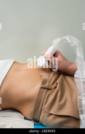 Teilansicht eines Arztes, der Nieren-Ultraschall einer Frau im Krankenhaus macht, Stockbild Stockfoto