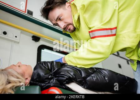 Sanitäter in Uniform, erste Hilfe für bewusstlosen Patienten im Rettungsfahrzeug, Stockbild Stockfoto