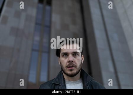 Deprimierter Mann draußen steht nachdenklich und schaut weg Stockfoto