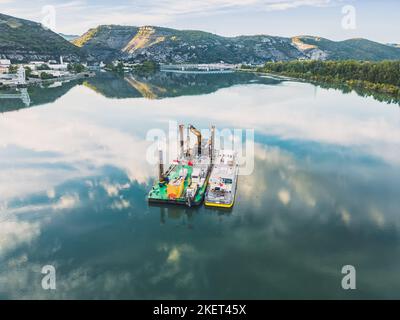 Le Pouzin, Frankreich - 22. November 2022: Wasserkahn mit Flussbettbagger an der Rhone in Frankreich Stockfoto