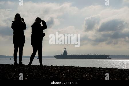 Die Menschen schauen nach, wie die USS Gerald R. Ford in die Stokes Bay im Solent eintrifft, da das „größte Kriegsschiff der Welt“ während seiner Jungfernfahrt vier Tage vor der Küste von Hampshire vor Anker gehen wird. Bilddatum: Montag, 14. November 2022. Stockfoto