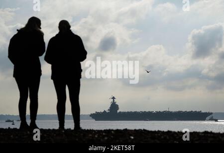 Die Menschen schauen nach, wie die USS Gerald R. Ford in die Stokes Bay im Solent eintrifft, da das „größte Kriegsschiff der Welt“ während seiner Jungfernfahrt vier Tage vor der Küste von Hampshire vor Anker gehen wird. Bilddatum: Montag, 14. November 2022. Stockfoto