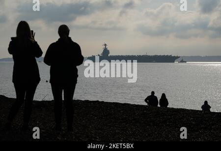 Die Menschen schauen nach, wie die USS Gerald R. Ford in die Stokes Bay im Solent eintrifft, da das „größte Kriegsschiff der Welt“ während seiner Jungfernfahrt vier Tage vor der Küste von Hampshire vor Anker gehen wird. Bilddatum: Montag, 14. November 2022. Stockfoto