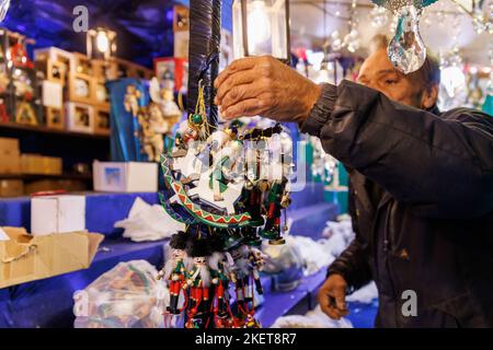 Nürnberg, Deutschland. 14.. November 2022. Während der Aufstellarbeiten auf dem Nürnberger Weihnachtsmarkt legt ein Stallbetreiber Weihnachtsbaumschmuck in seinen Stall. Der Nürnberger Weihnachtsmarkt wird am 25. November eröffnet. Quelle: Daniel Karmann/dpa/Alamy Live News Stockfoto