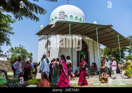 Bijapur, Karnataka, Indien : Pilger sitzen am Pilgerort Jod Gumbad aus dem 17. Jahrhundert. Stockfoto