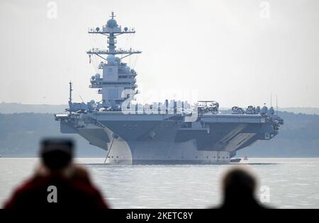 Die Menschen sehen aus wie die USS Gerald R. Ford, während sie in Stokes Bay im Solent vor Anker gehen, da das „größte Kriegsschiff der Welt“ während seiner Jungfernfahrt vier Tage vor der Küste von Hampshire vor Anker gehen wird. Bilddatum: Montag, 14. November 2022. Stockfoto