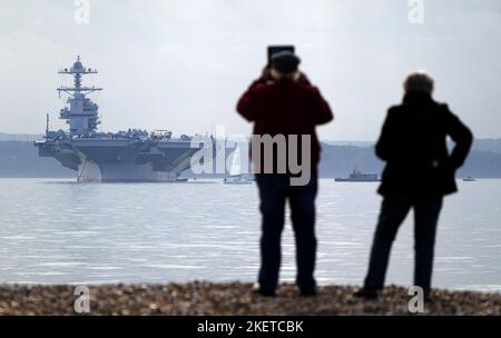 Die Menschen sehen aus wie die USS Gerald R. Ford, während sie in Stokes Bay im Solent vor Anker gehen, da das „größte Kriegsschiff der Welt“ während seiner Jungfernfahrt vier Tage vor der Küste von Hampshire vor Anker gehen wird. Bilddatum: Montag, 14. November 2022. Stockfoto