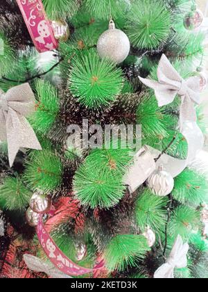 Weihnachtsdekorationen hängen auf dem grünen Baum, Kunststoff, italienische Kultur. Stockfoto