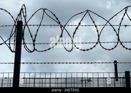 Sicherheitskonzept Mit Razor Wire Fence Und Kamera Gegen Stürmischen Himmel Stockfoto