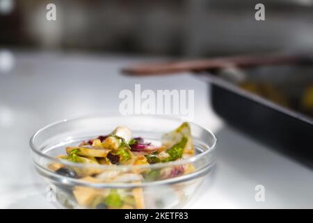 Defocus Glasschüssel mit Salat auf weißem Hintergrund. Verschiedene Blätter von verschiedenen Blattgemüse, Mangold, Spinat, Rucola im Salat. Salat mit Käse Stockfoto