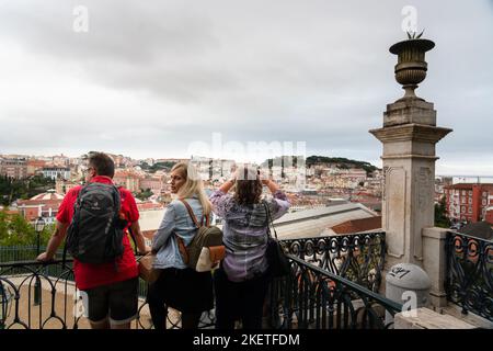 Touristen im Miradouro de São Pedro de Alcântara in Lissabon, Portugal. Dieser große terrassenförmige mirador bietet einen Panoramablick auf die Stadt. Stockfoto