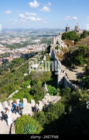 Touristen erklimmen die beeindruckenden Festungsmauern und Türme der Maurischen Burg aus dem 10. Jahrhundert (Castelo dos Mouros) oberhalb von Sintra, Portugal. Stockfoto