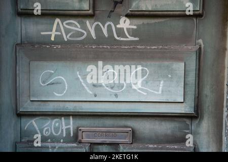 Namen geschrieben in Graffiti an einer alten verblassten Tür und Briefkasten auf einem Herrenhaus oberhalb von Sintra, Portugal. Stockfoto