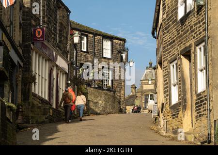 Haworth, West Yorkshire, Großbritannien. Zu Fuß bis zum oberen Ende der gepflasterten Hauptstraße. Stockfoto