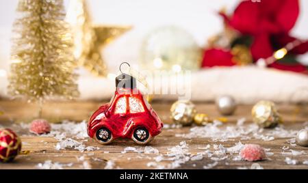 Weihnachts-Spielzeugauto und Details der Weihnachtsdekor auf einem unscharfen Hintergrund. Stockfoto