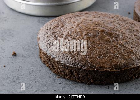 Ungefrostter Schokoladenkuchen auf grauer Arbeitsplatte mit Platz zum Kopieren Stockfoto