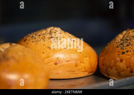 Nahaufnahme, frisch gebackene Brötchen in der Bäckerei aus nächster Nähe. Stockfoto
