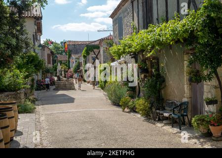 18. Juli 2019 - Pujols, Frankreich: Historische Architektur und Sommersonne bringen Besucher nach Pujols, Lot-et-Garonne, Frankreich. Stockfoto