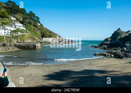 20.. September 2019 - Polperro, Großbritannien: Einige Besucher genießen die Herbstsonne am Eingang zum malerischen Polperro Harbour, Cornwall, England, Großbritannien, Stockfoto