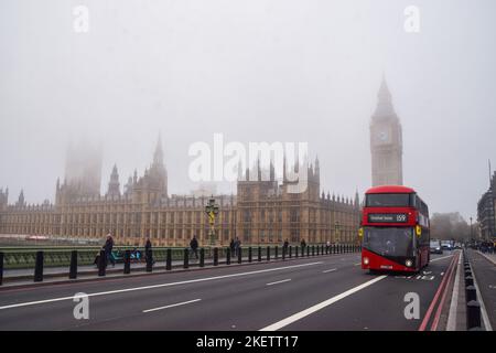 London, Großbritannien. 14.. November 2022. Ein Bus fährt an den Houses of Parliament und Big Ben an der Westminster Bridge vorbei, während dichter Nebel die Hauptstadt bedeckt. Kredit: Vuk Valcic/Alamy Live Nachrichten Stockfoto