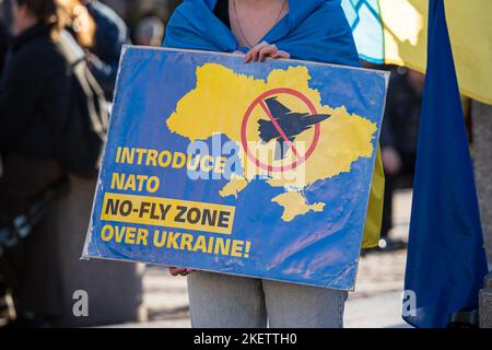 Einführung einer NATO-Flugverbotszone über dem Schild der Ukraine, das von einer Frau in Krakau gehalten wird. Unterstützung der Ukraine in Polen. Krakau, Polen - 10. November 2022. Stockfoto