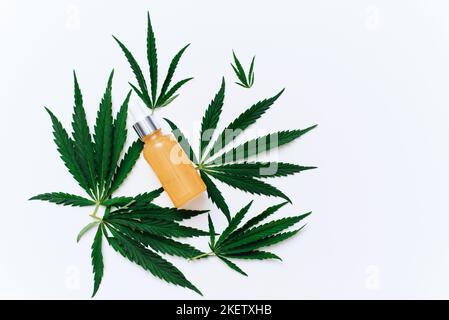 Zusammensetzung mit Flasche CBD-Öl, Hanfblatt isoliert auf weißem Hintergrund, flach liegend. Entspannungsbehandlung. Stockfoto