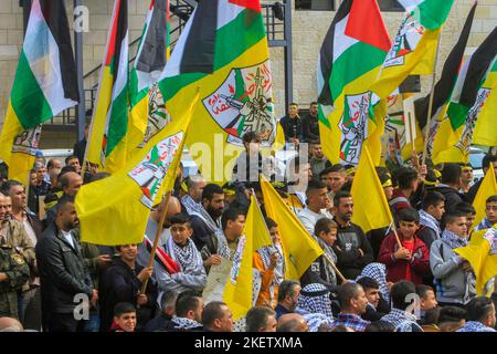 Nablus, Palästina. 14.. November 2022. Anhänger der palästinensischen Fatah-Bewegung schwenken bei einer Kundgebung zum Gedenken an den 18.. Todestag des verstorbenen palästinensischen Führers Yasser Arafat in der Stadt Nablus im Westjordanland Flaggen. Kredit: SOPA Images Limited/Alamy Live Nachrichten Stockfoto